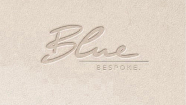 Embossed 'Blue Bespoke' logo on a textured beige background